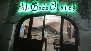 The entrance to the Al Baba Hotel with a green neon sign. - Ali Baba Hotel (Dahab)