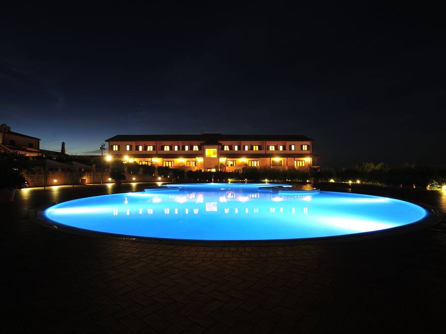 Una piscina al aire libre, sombrillas, tumbonas