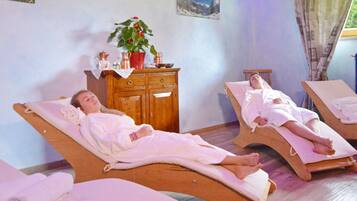 Relax in a serene spa setting with two reclining massage chairs and a peaceful ambiance.