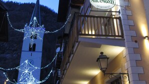 A building with a sign reading "MIRAMONTI APARTMENT" and a balcony with wooden railings. - Miramonti (Valtournenche)