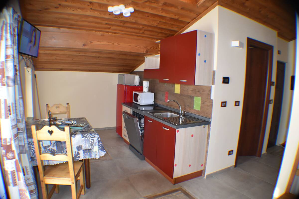 A compact kitchen with wooden cabinets, a sink, and a microwave.