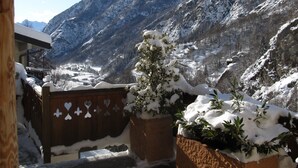 A snowy mountain landscape with a wooden fence and a small tree covered in snow. - Miramonti (Valtournenche)