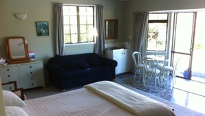 A bedroom with a bed, a sofa, a desk, and a chair. - Somersal Bed & Breakfast (Pirongia)