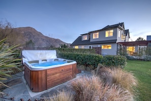 A modern two-story house with a hot tub in the backyard. - Queenstown Country Lodge (Lake Hayes)