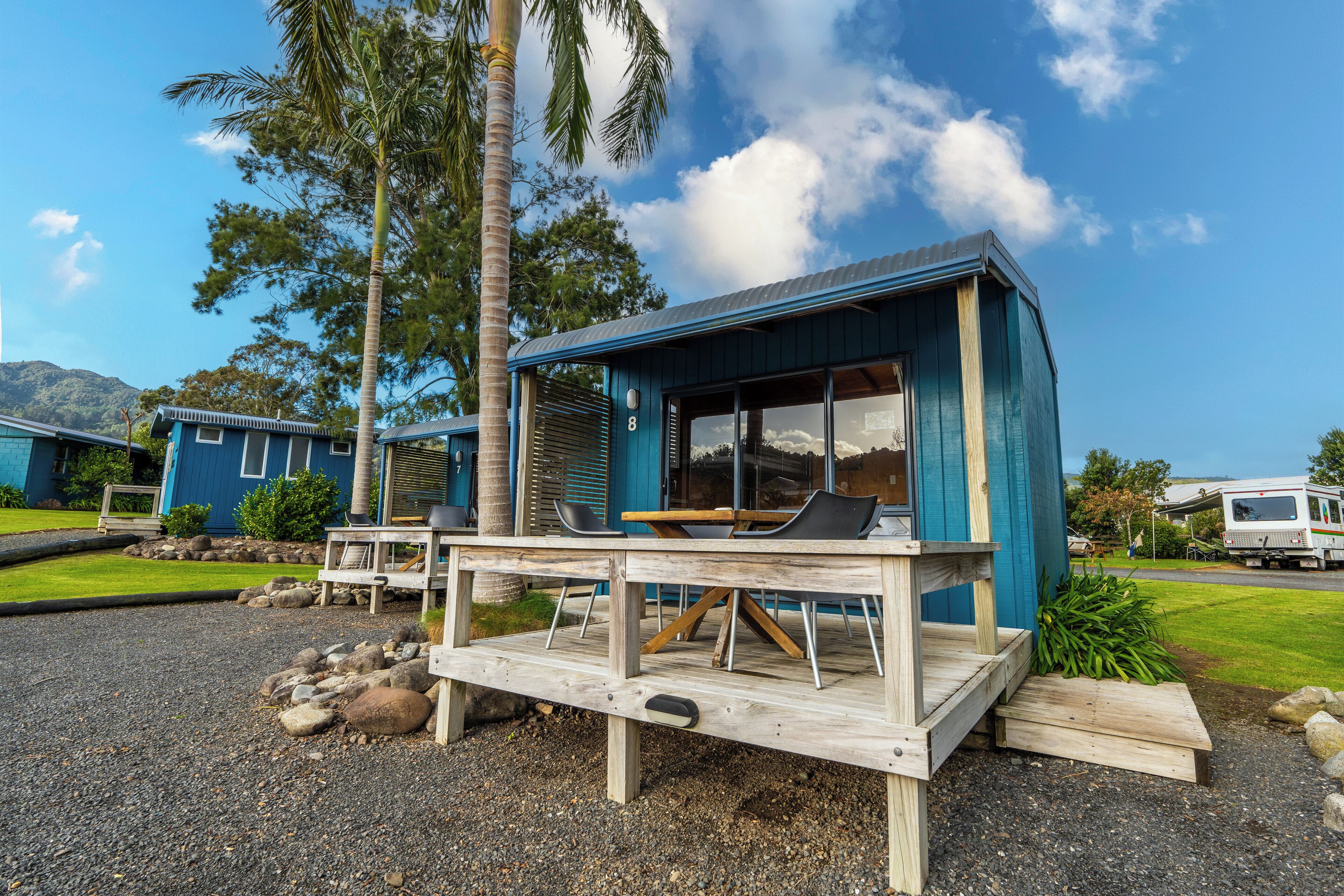 A small, single-story building with a deck and outdoor seating area.