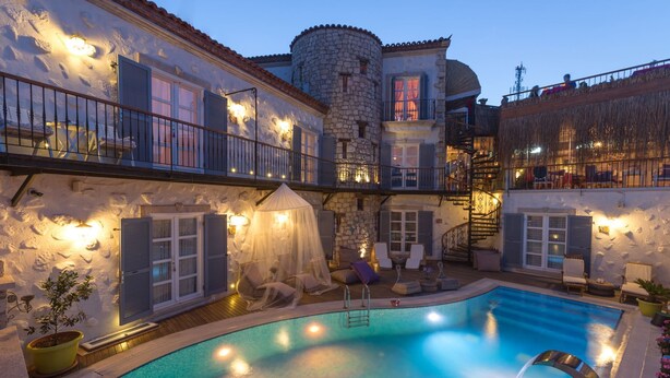 A pool area with a stone wall, a covered seating area, and a staircase. - Chigdem Hotel - Special Class (Cesme)