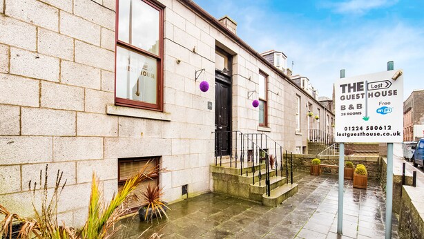 A building with a sign for 'The Guest House' offering 28 rooms, free Wi-Fi, and B&B services. - Lost Guest House - Aberdeen (Aberdeen)