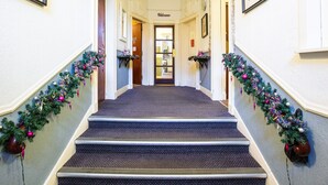 A hallway with a carpeted staircase, decorated with festive garlands and ornaments. - Lost Guest House - Aberdeen (Aberdeen)