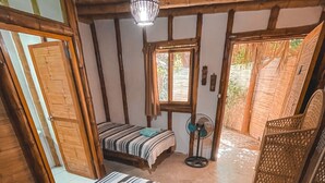 Quarto com cama, ventoinha e janela.