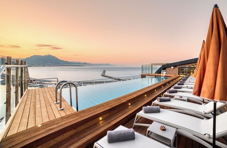 Una piscina al aire libre, sombrillas, sillones reclinables de piscina. Numa Port Hotel