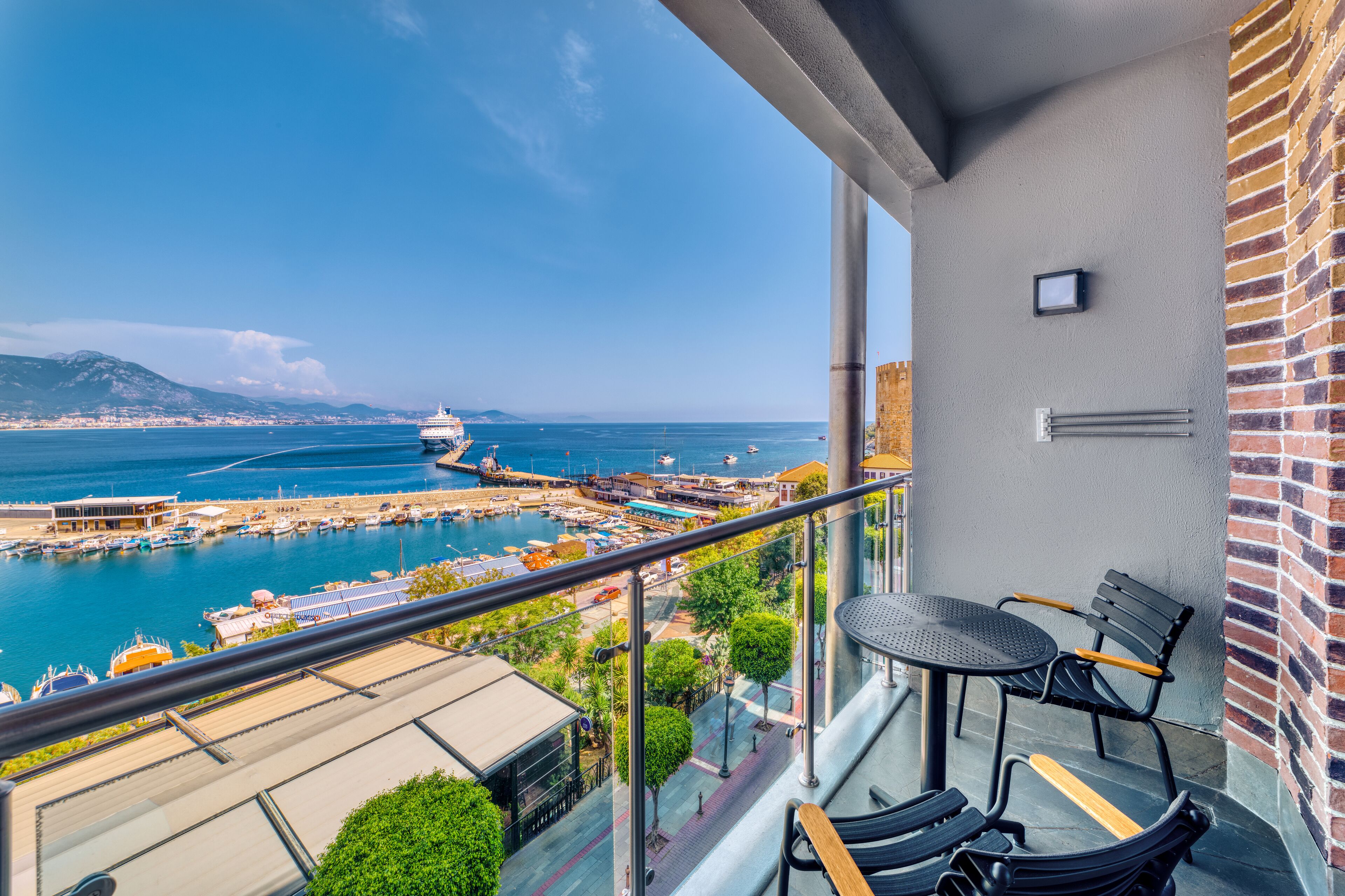 Un balcon avec vue sur la mer, une table et deux chaises.