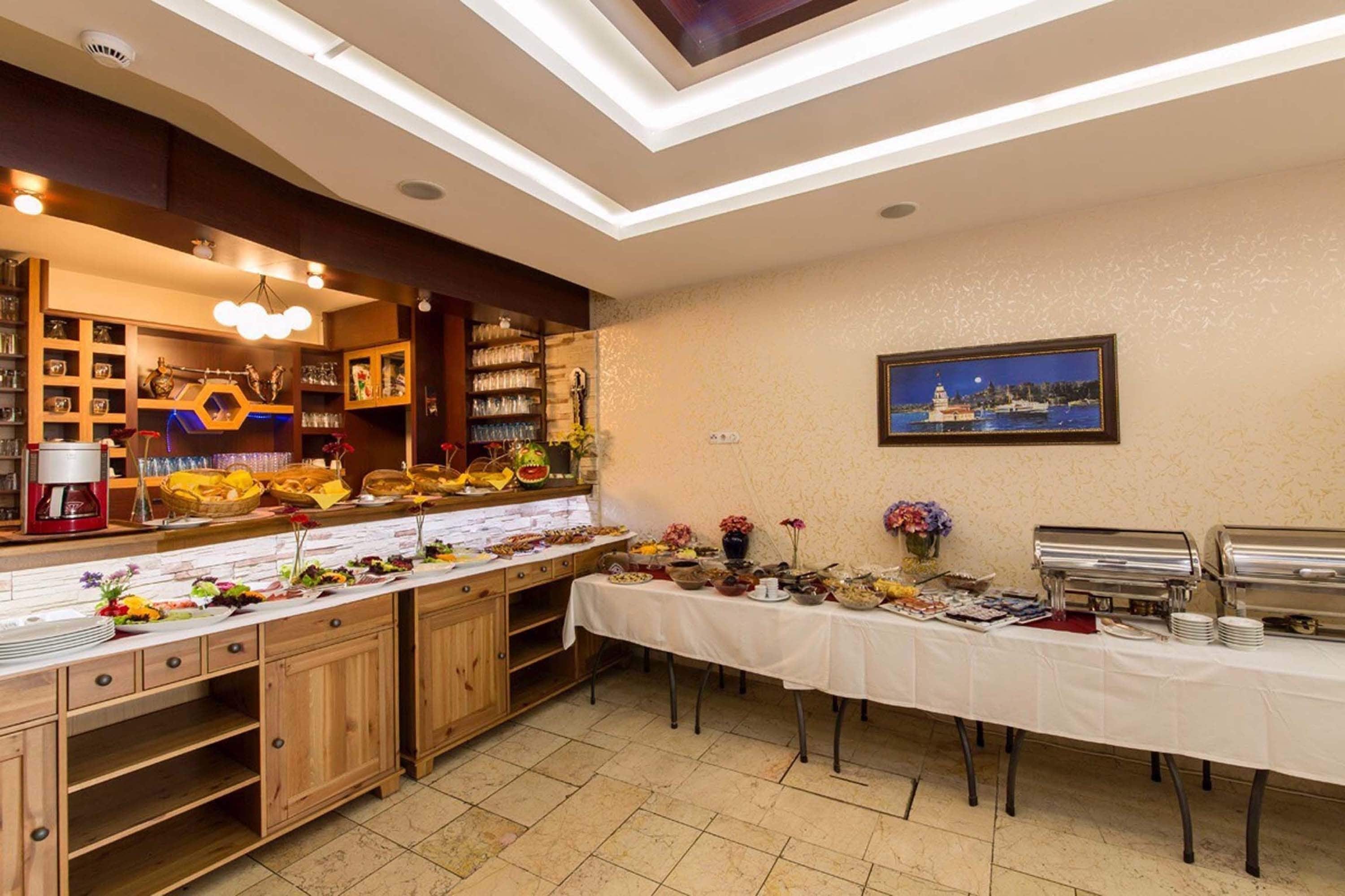 A buffet setup with a variety of dishes and drinks, a coffee machine, and a framed picture on the wall.