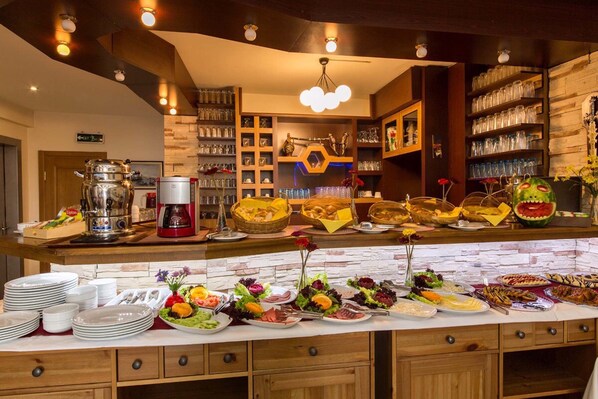A buffet setup with various food items and a coffee machine.