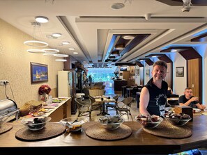 A modern restaurant interior with a buffet setup, wooden furniture, and a view of the city through the window. - Ipekyolu Hotel (Istanbul)
