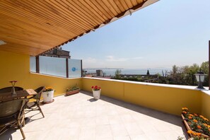 A balcony with a view of the sea, a wooden pergola, and potted plants. - Ipekyolu Hotel (Istanbul)