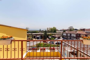 A balcony with a yellow wall and red railing, overlooking a street with cars and buildings. - Ipekyolu Hotel (Istanbul)