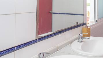Un baño con dos lavamanos, un espejo y una puerta roja.