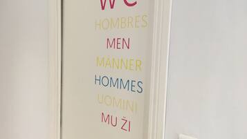 Eine Tür mit mehrsprachiger Beschilderung, die die Herrentoilette auf Englisch, Spanisch, Französisch, Deutsch und Türkisch kennzeichnet.