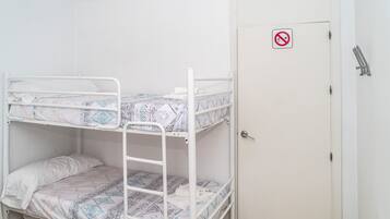 A bunk bed room with a white door and a no-smoking sign.