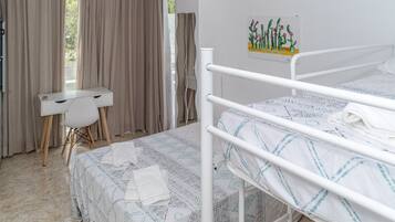 Un dormitorio con cama, escritorio y silla.