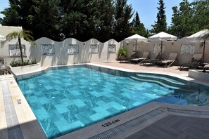 Piscina a l'aire lliure de temporada, para-sols i gandules 