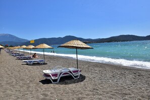 En la playa, camas de playa, sillas reclinables de playa, sombrillas