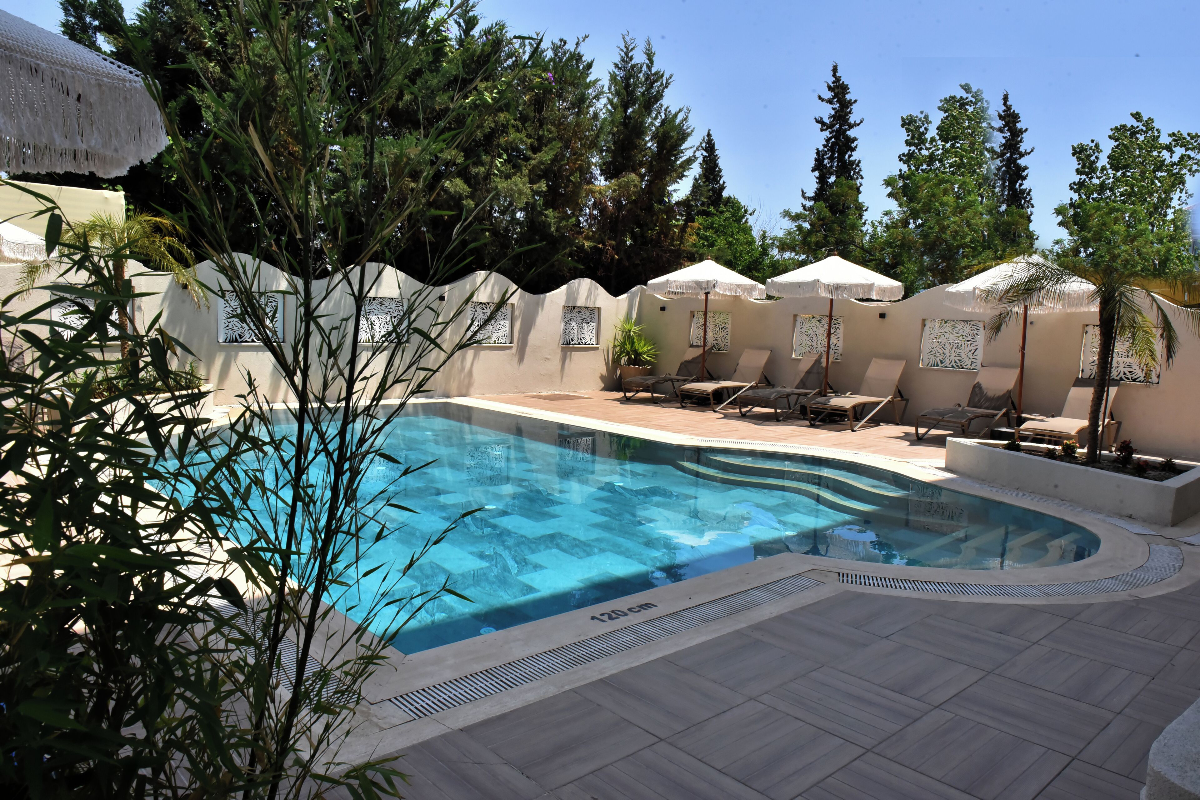 季节性开放的室外游泳池，池畔遮阳伞，日光浴躺椅