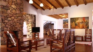 Un interior rústico con paredes de piedra, muebles de madera y obras de arte.