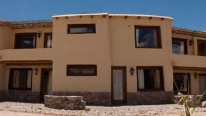 Un edificio de varios pisos con fachada curva, múltiples ventanas y cimientos de piedra.