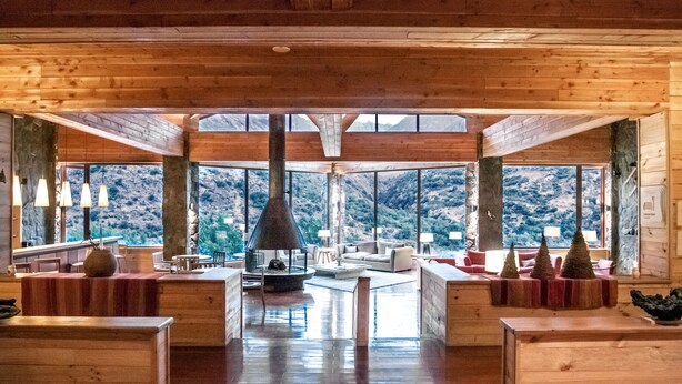 A spacious wooden interior with large windows offering mountain views. - Noi Puma Lodge (Machalí)