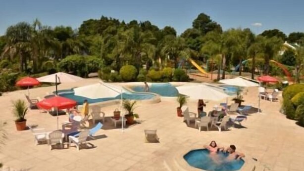 A pool area with multiple pools, lounge chairs, and umbrellas.