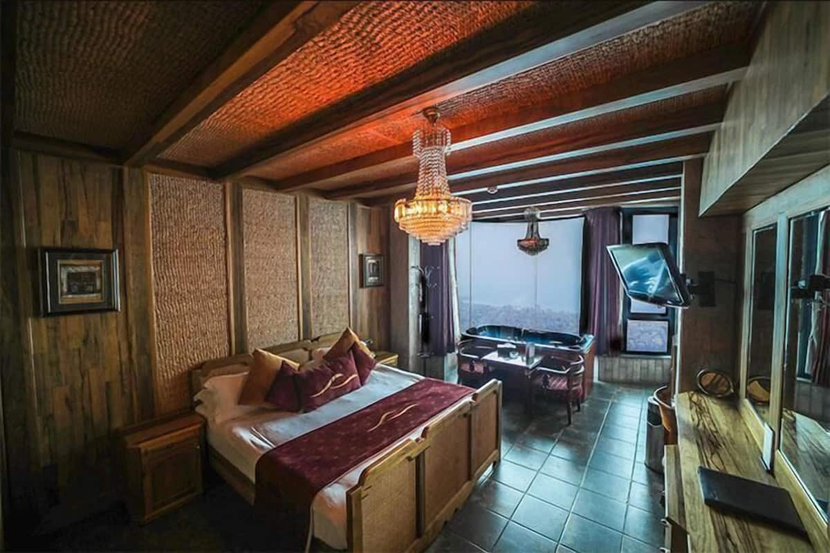 A bedroom with a wooden bed, a large window, and a chandelier.