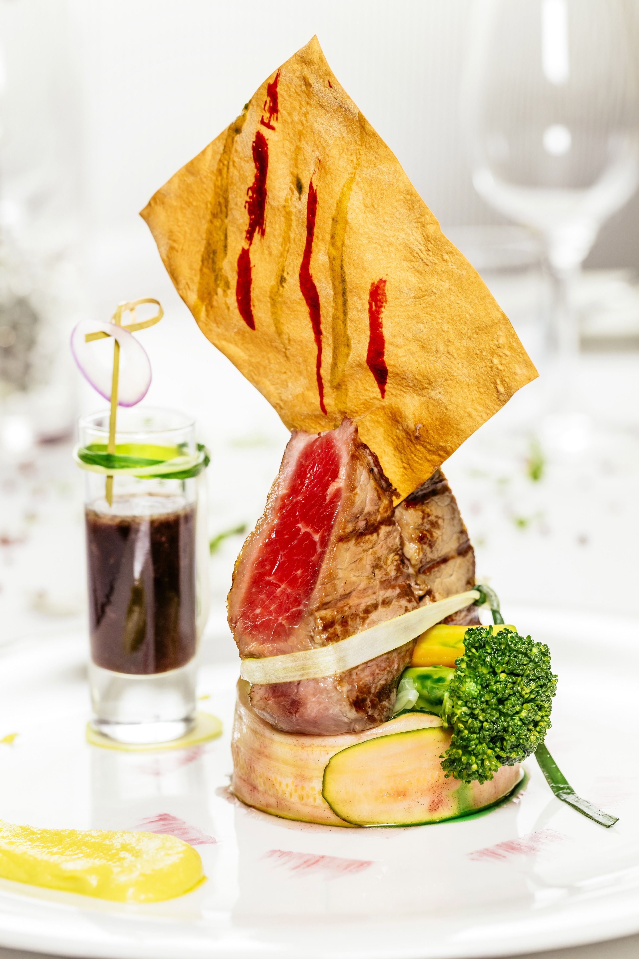Een bord met een steak, groenten en een decoratief papiertje.