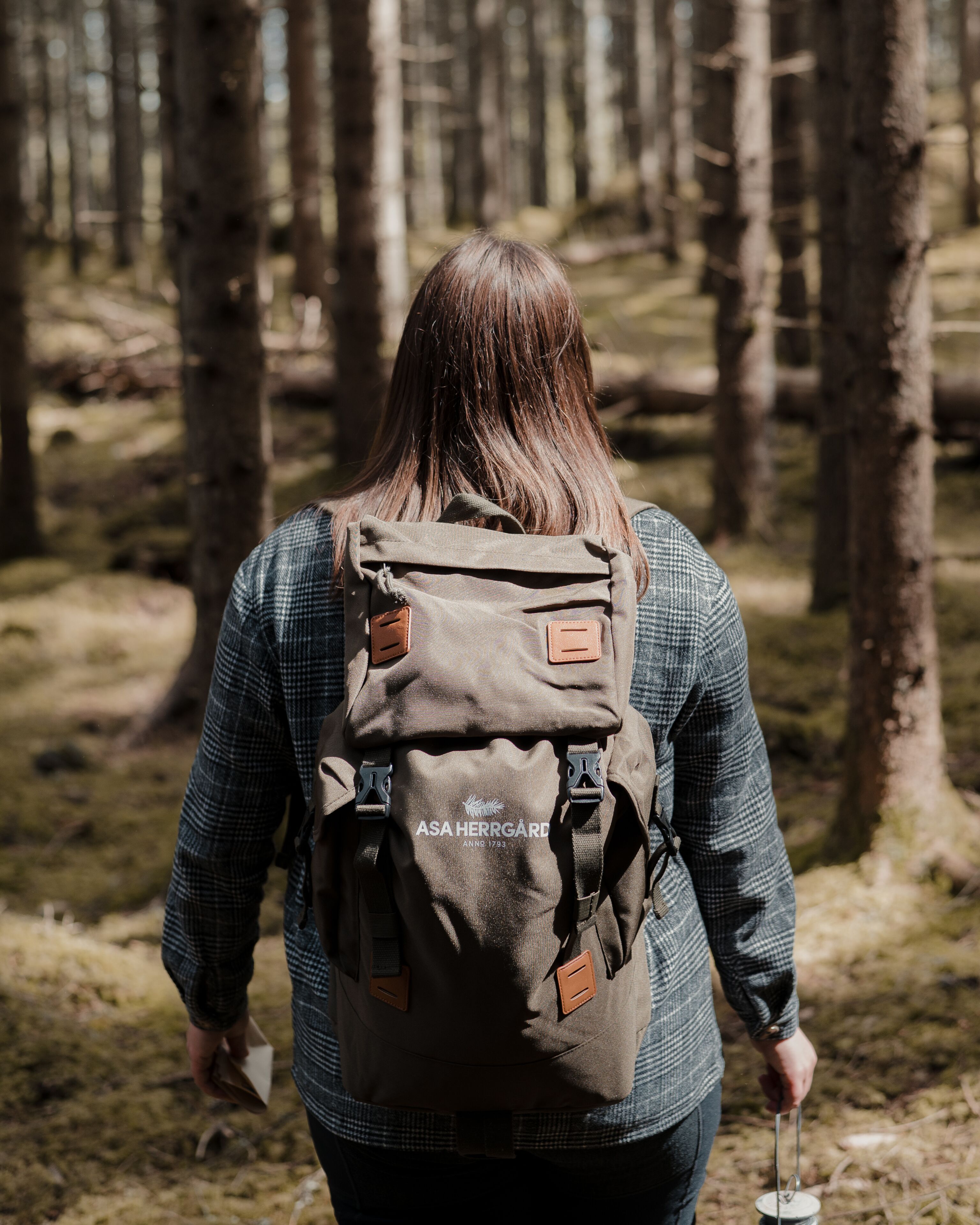 Une personne portant un sac à dos qui marche dans une forêt.