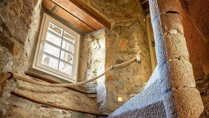 Una escalera de piedra en un edificio histórico, con un ventanal que proporciona luz natural.