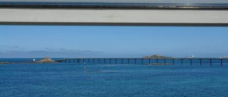 A view of a pier extending into a body of water with a clear sky.