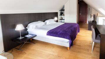 A modern bedroom with a bed, bedside tables, a desk, and a wardrobe.