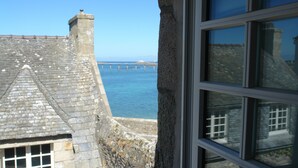 Un edificio de piedra con vistas al mar y un muelle.