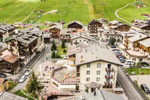 A hotel with a central courtyard, outdoor seating, and a ski lift in the background.