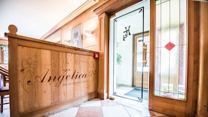 A wooden reception desk with the name 'Angelica' and 'BAR-RESTAURANTE-PIZZERIA' engraved on it. - Hotel Angelica (Livigno)