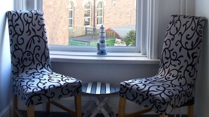 Two patterned chairs facing a window with a checkered blind. - Timrick Lodge Hotel (Weymouth)