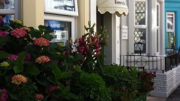 A corner building with a white awning labeled "Timid." - Timrick Lodge Hotel (Weymouth)