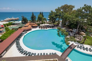 Un'ampia piscina all'aperto con lettini e vista sul mare.