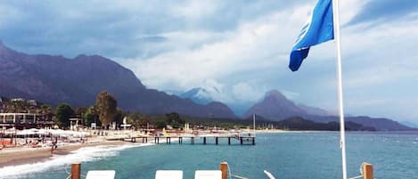 Aan een privéstrand, ligstoelen, parasols, strandlakens