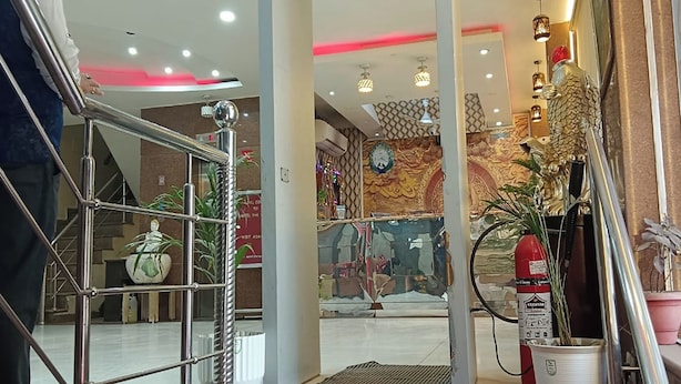 A hotel lobby with a modern staircase, decorative wall patterns, and potted plants. - Hotel RTS Plaza Near IGI Airport (New Delhi)