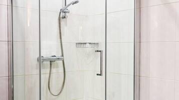 Un baño moderno con ducha envuelta en vidrio, una bañera blanca y un perchero para toallas.