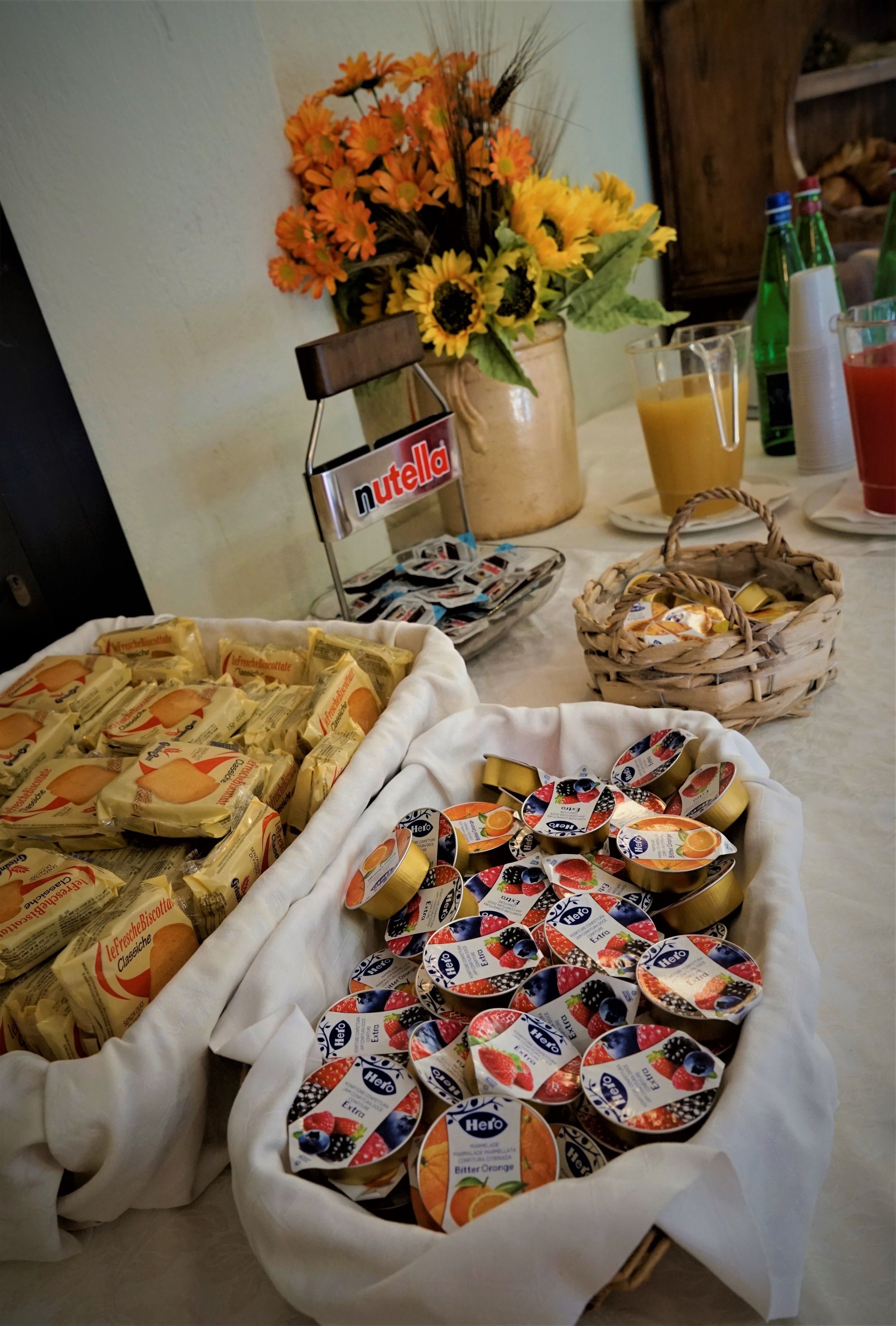 Una mesa de buffet con diversos alimentos, incluyendo galletas envasadas y vasos de yogur.