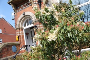 A building with a brick facade, a large arched window, and a door. - Longview Hotel (Knutsford)