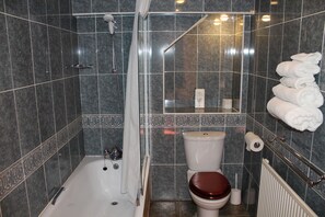 Un baño con bañera, inodoro y ducha.