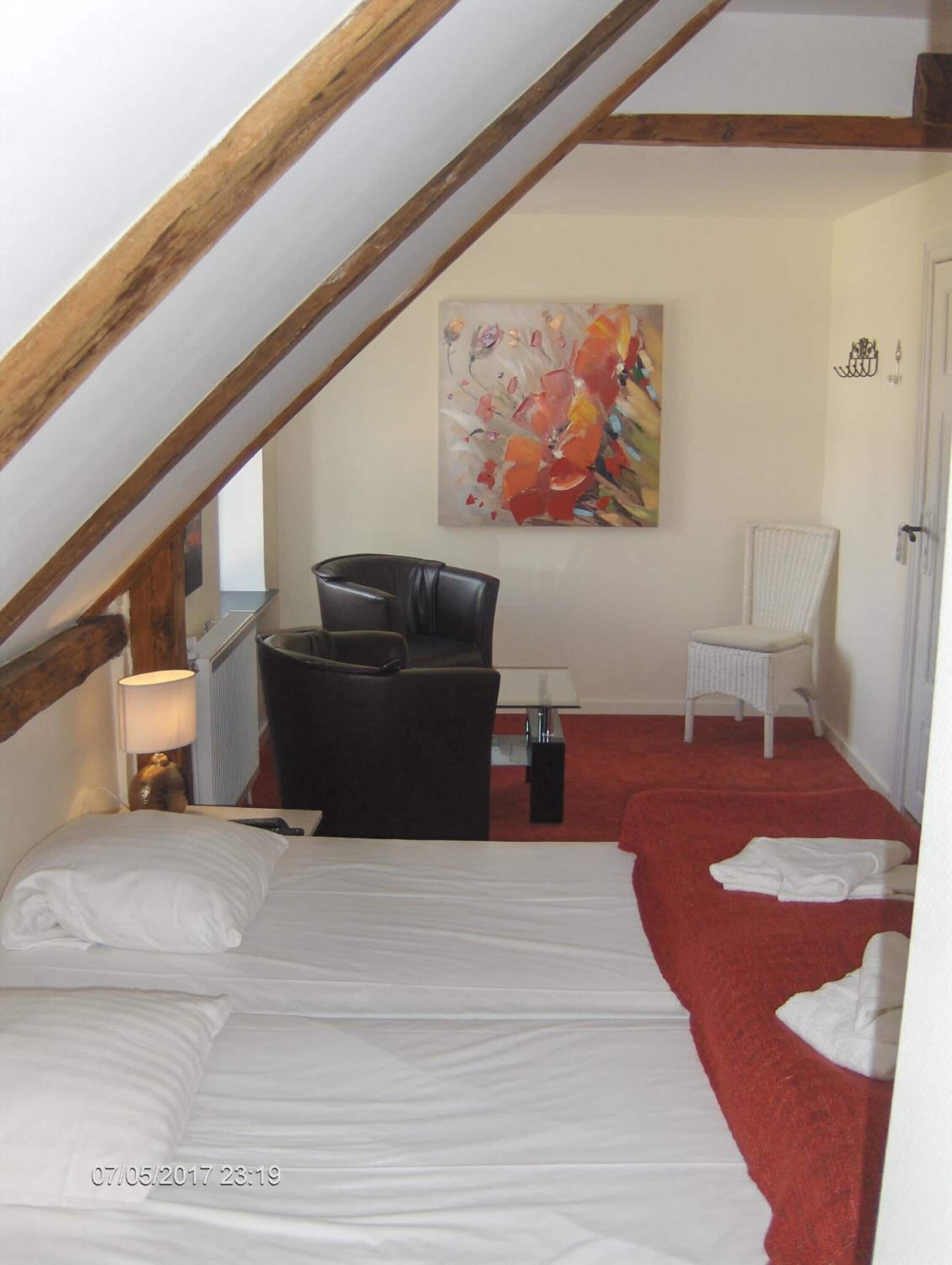 Ein Schlafzimmer mit einem Bett, einem Schreibtisch, einem Stuhl und einem Bild an der Wand.